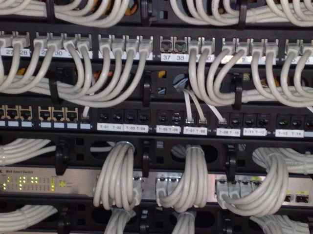 Hálózati switch és patch panel rackszekrényben, rendezett kábelezéssel